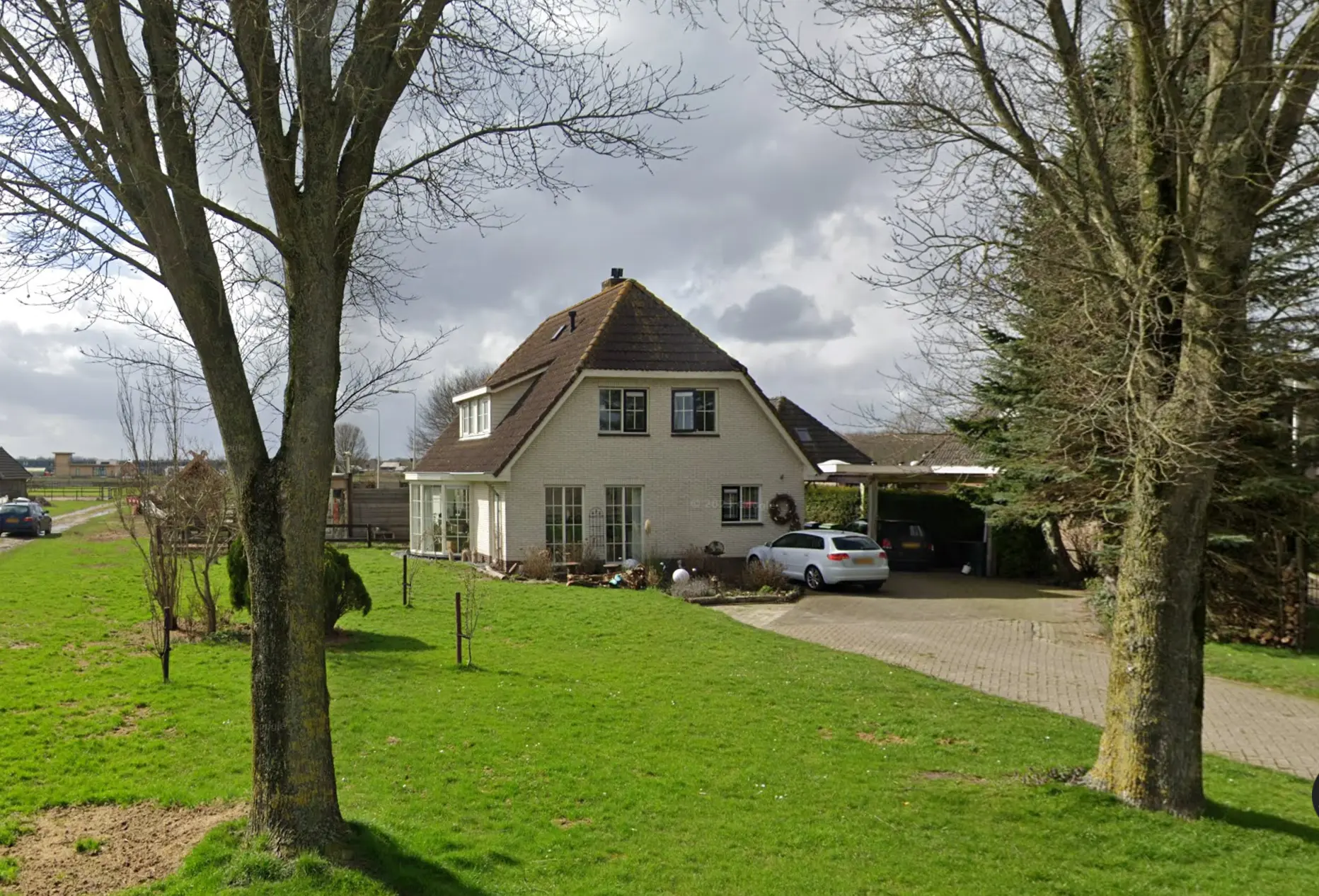 Foto van de woning met gazon en oude bomen in Almere Hout